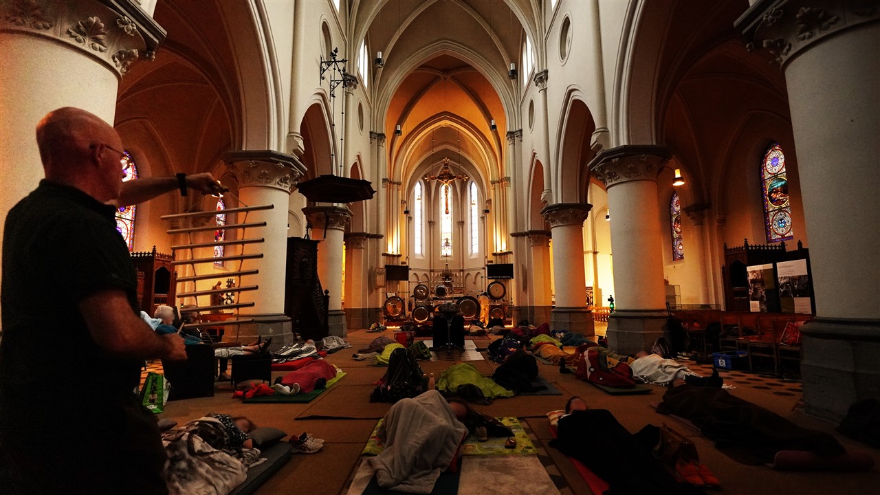 deelnemers liggen tijdens een klankreis in de sfeervolle OLV-kerk in Kampenhout