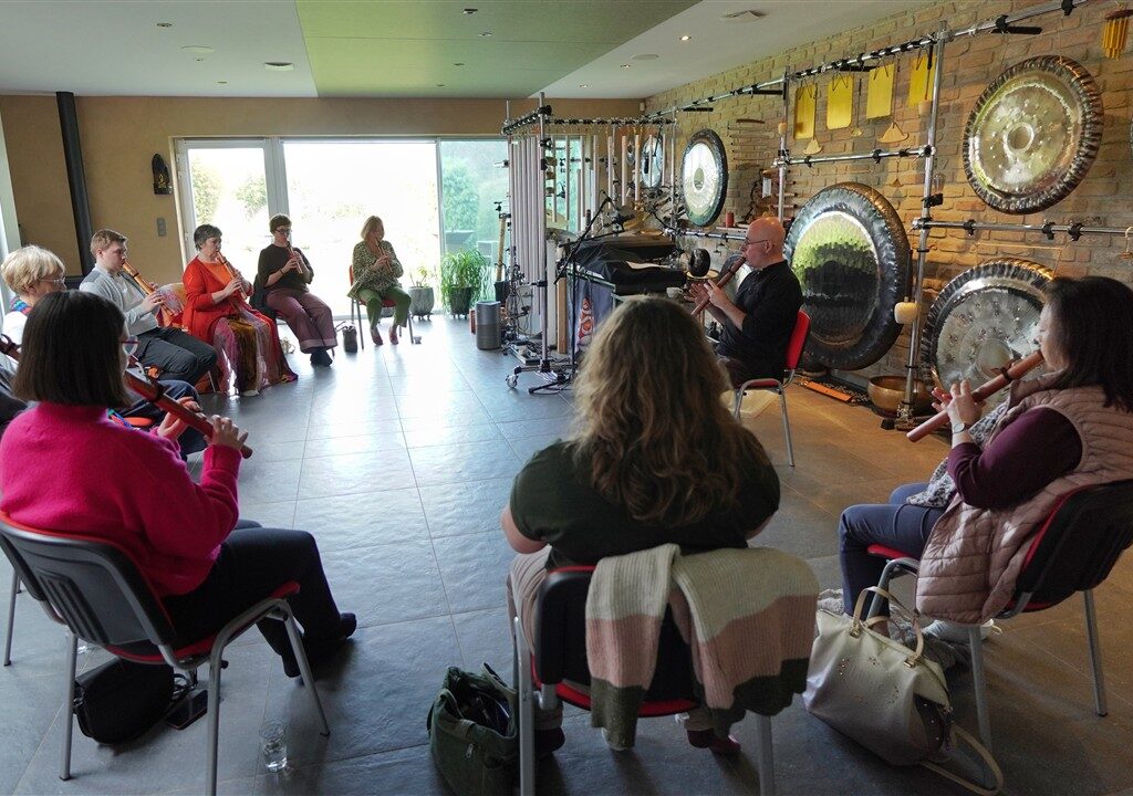 de deelnemers van de workshop Native American Flute spelen samen onder begeleiding van docent Andy Vanbeveren