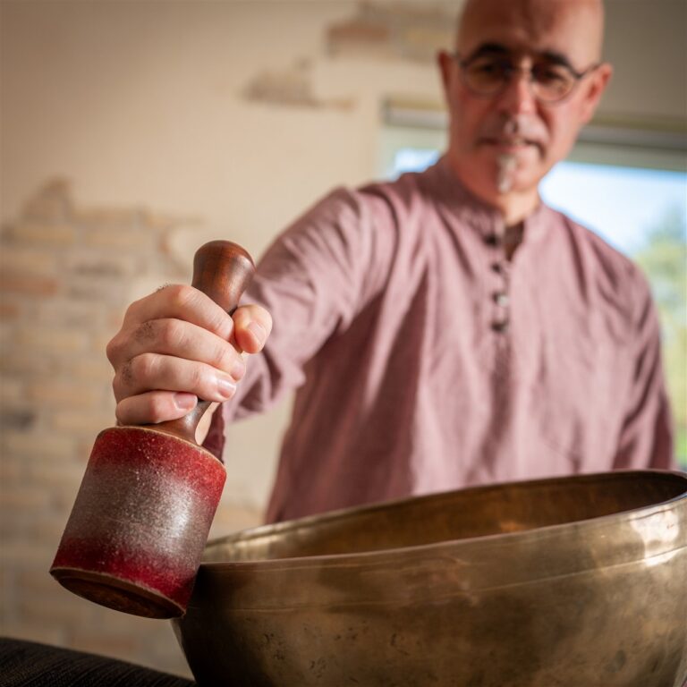 Andy Vanbeveren draait een klankschaal aan tijdens een ontspannende klankschaalmassage.